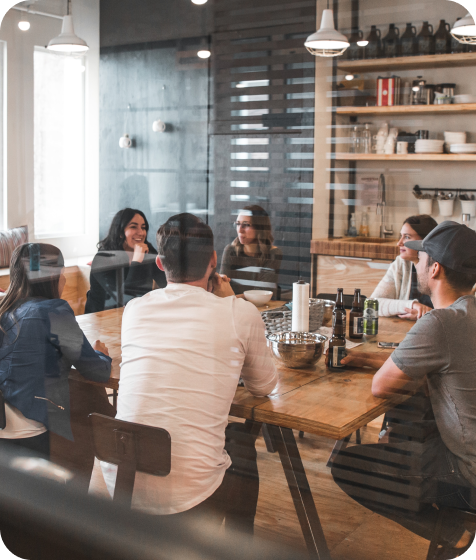 Lidi sedící u stolu v kuchyňce v práci